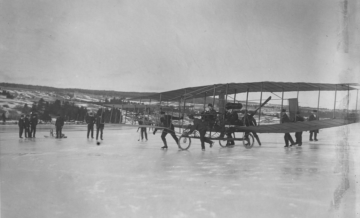 image J.A.D. McCurdy et le Silver Dart sont guidés par des patineurs sur la baie Baddeck le 23 février 1909.